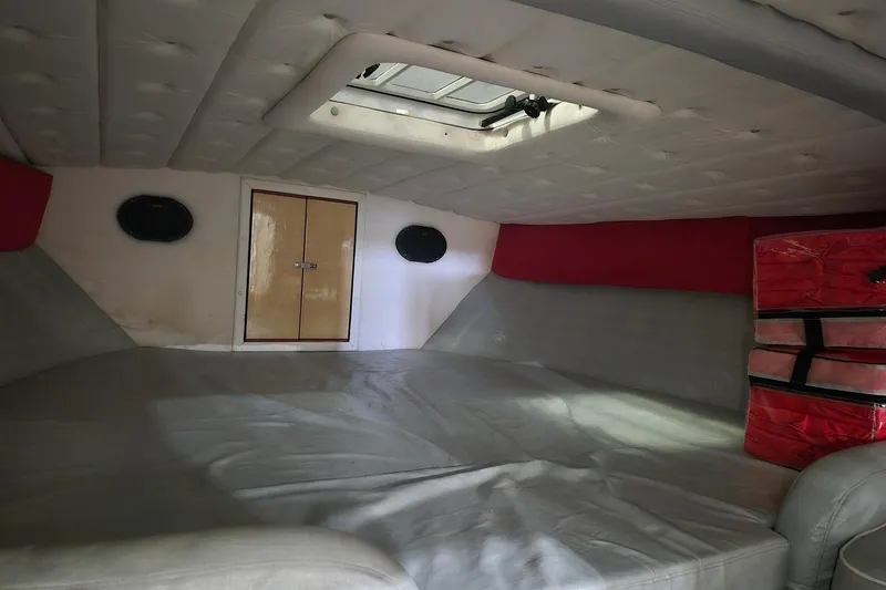 Slide: The Image of Interior cabin of a 1982 Magnum 40 boat with cushioned seating and storage. - 37