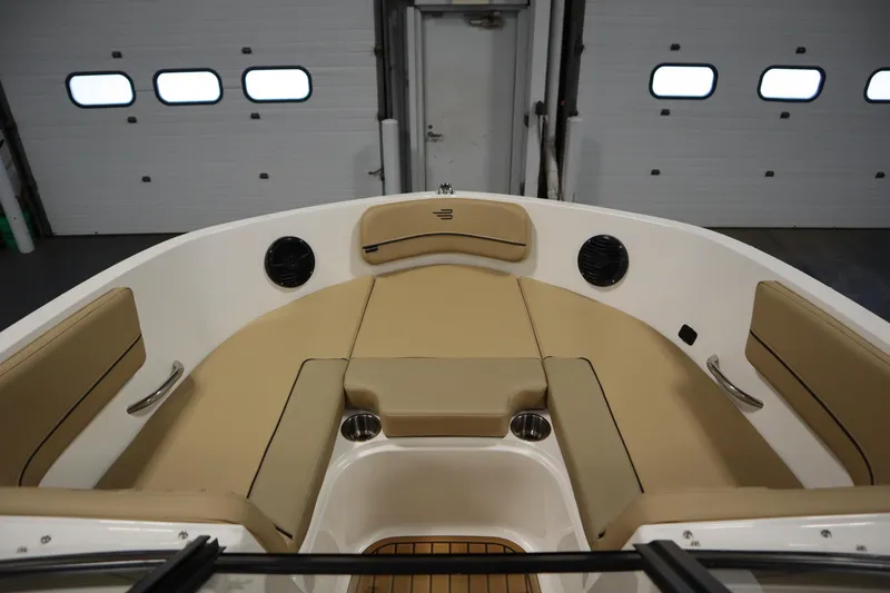 Slide: The Image of 2025 Bayliner VR6 Bowrider OB interior with beige seating and cup holders. - 10
