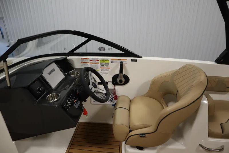 Slide: The Image of 2025 Bayliner VR6 Bowrider OB cockpit with steering wheel and beige seating. - 16