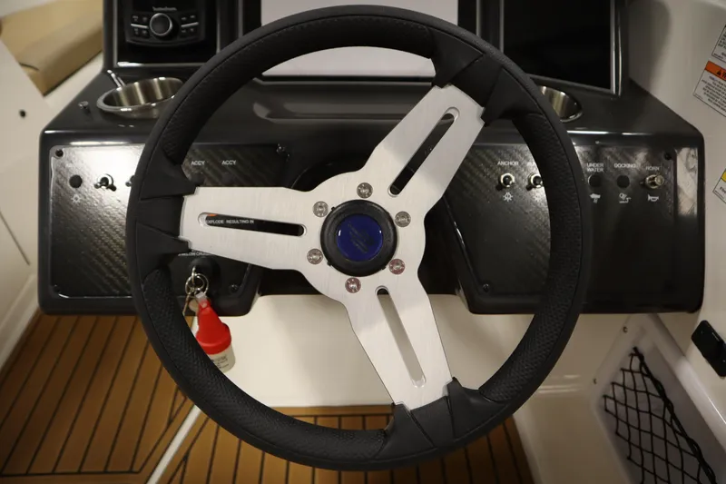 Slide: The Image of Steering wheel of 2025 Bayliner VR6 Bowrider OB with control panel and switches. - 18