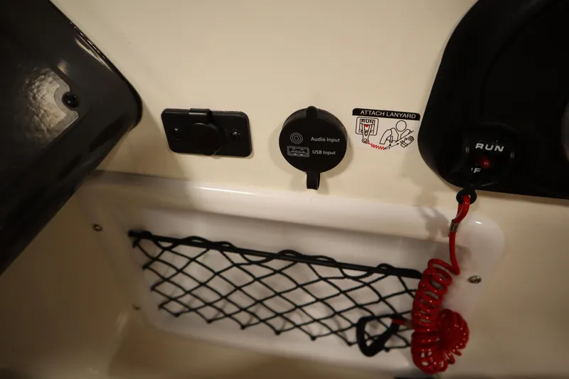 Slide: The Image of 2025 Bayliner VR6 Bowrider OB dashboard with audio input, USB port, and safety lanyard. - 24