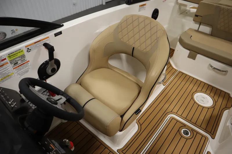 Slide: The Image of 2025 Bayliner VR6 Bowrider OB interior with tan seating and wood-patterned flooring. - 27