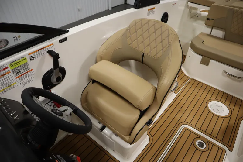 Slide: The Image of 2025 Bayliner VR6 Bowrider OB interior with tan seating and steering wheel. - 28