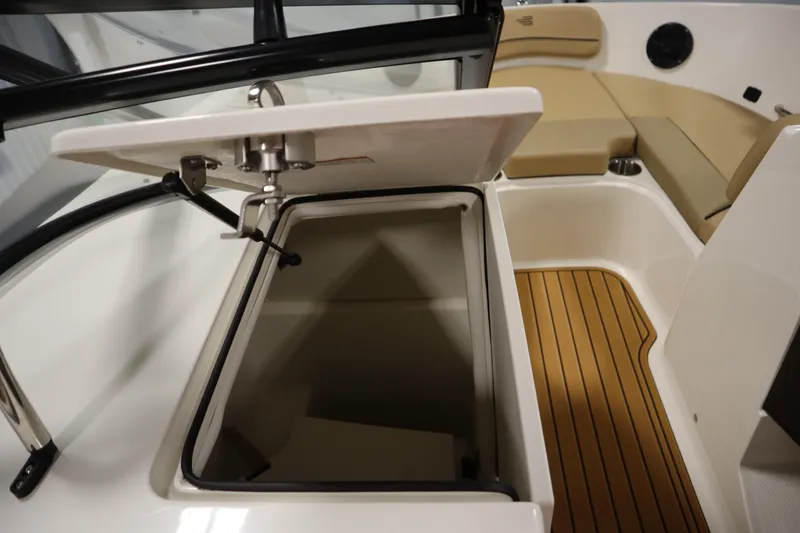 Slide: The Image of 2025 Bayliner VR6 Bowrider OB interior storage compartment with open lid and seating area. - 30