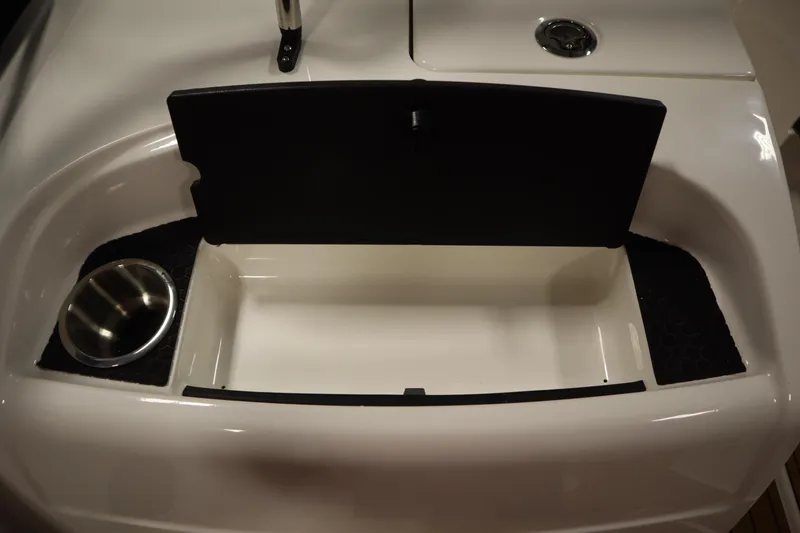 Slide: The Image of 2025 Bayliner VR6 Bowrider OB storage compartment with cup holder and sleek design. - 32