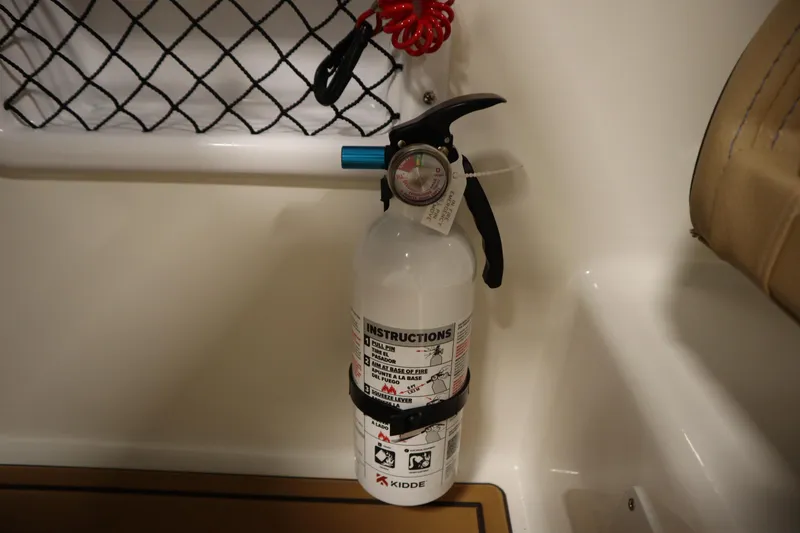 Slide: The Image of Fire extinguisher on 2025 Bayliner VR6 Bowrider OB boat, secured with a strap. - 33