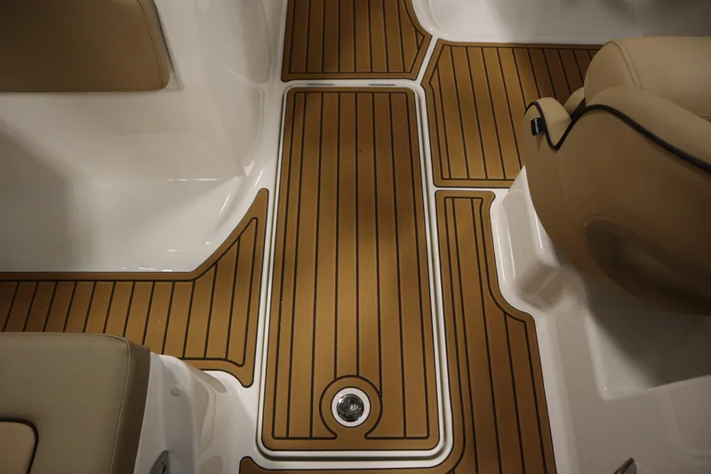 Slide: The Image of 2025 Bayliner VR6 Bowrider OB interior with teak-style flooring and beige seating. - 34