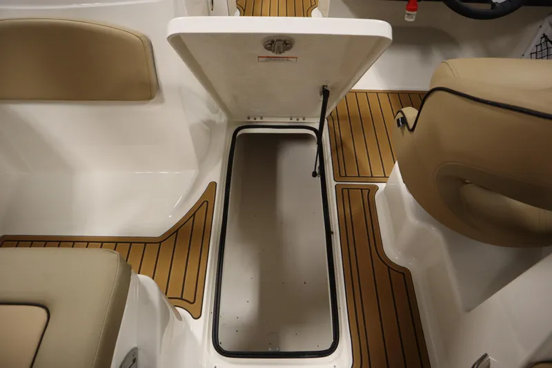 Slide: The Image of 2025 Bayliner VR6 Bowrider OB interior storage compartment with tan seating and wood-style flooring. - 35
