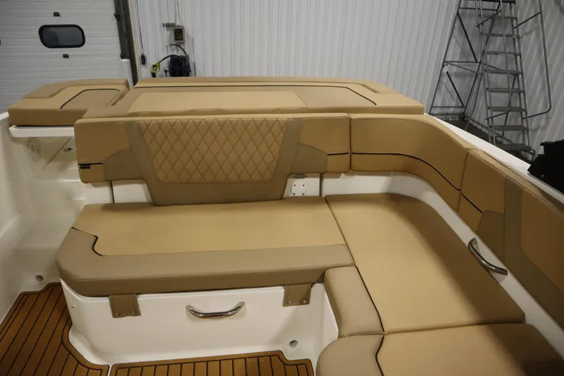Slide: The Image of 2025 Bayliner VR6 Bowrider OB interior with tan cushioned seating and wood flooring. - 40