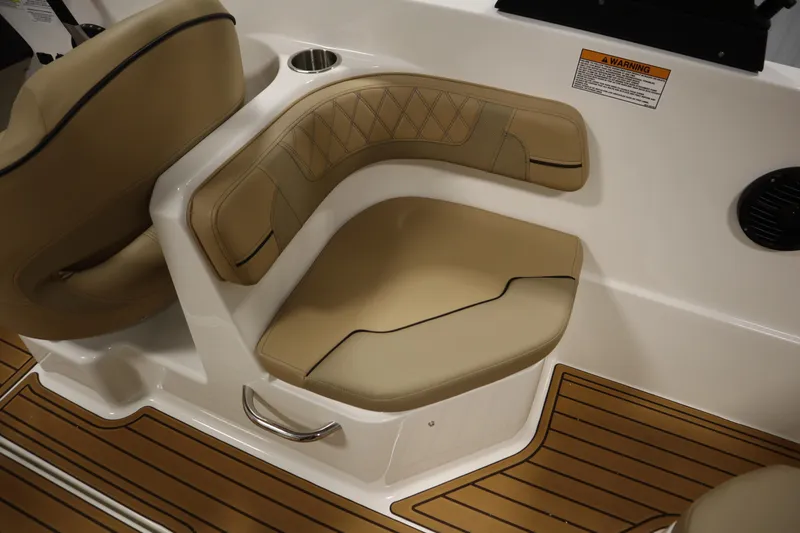 Slide: The Image of 2025 Bayliner VR6 Bowrider OB interior seating with tan upholstery and wood-style flooring. - 42