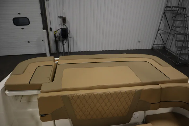 Slide: The Image of 2025 Bayliner VR6 Bowrider OB interior with tan cushioned seating in a garage setting. - 45