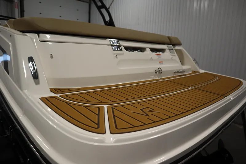 Slide: The Image of 2025 Bayliner VR6 Bowrider OB swim platform with teak-style decking in a showroom. - 50