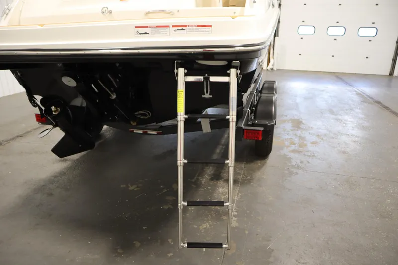 Slide: The Image of 2025 Bayliner VR6 Bowrider OB rear view with ladder and trailer in garage. - 51
