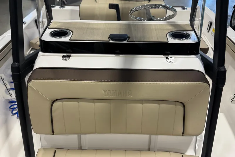 Slide: The Image of 2024 Yamaha Boats 190 FSH Sport interior with beige seating and steering wheel. - 12