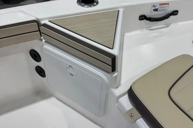 Slide: The Image of 2024 Yamaha Boats 190 FSH Sport interior detail with storage compartment and seating. - 13