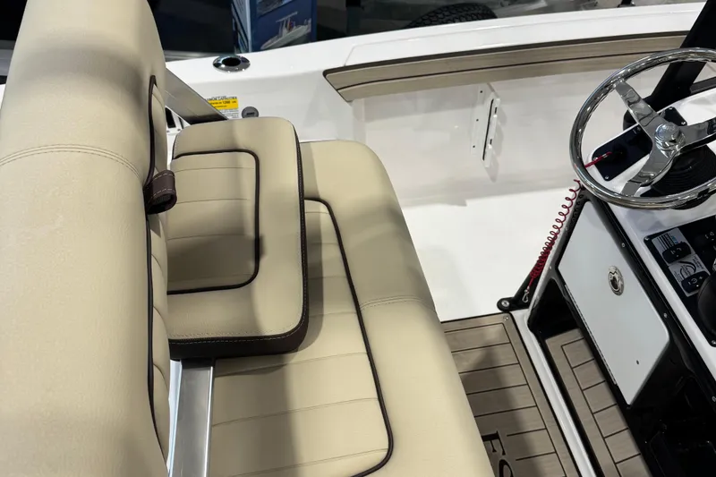 Slide: The Image of 2024 Yamaha Boats 190 FSH Sport interior with beige seating and steering wheel. - 3
