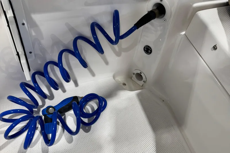 Slide: The Image of 2024 Yamaha Boats 190 FSH Sport with blue coiled hose in deck area. - 6