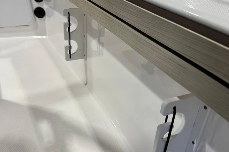 Slide: The Image of 2024 Yamaha Boats 190 FSH Sport interior detail with rod holders and sleek design. - 8