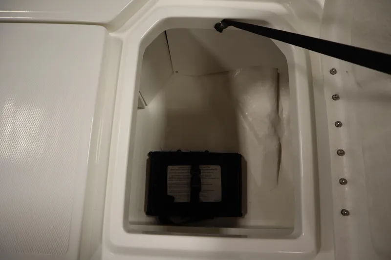 Slide: The Image of Storage compartment of 2026 Bayliner Trophy T18 boat, featuring a secured battery. - 13