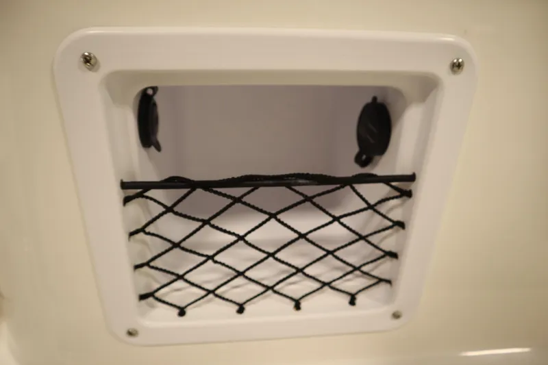 Slide: The Image of Storage compartment with netting on 2026 Bayliner Trophy T18 boat. - 18