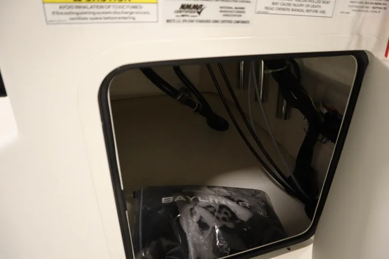 Slide: The Image of Bayliner Trophy T18 2026 interior compartment with wiring and storage space. - 27