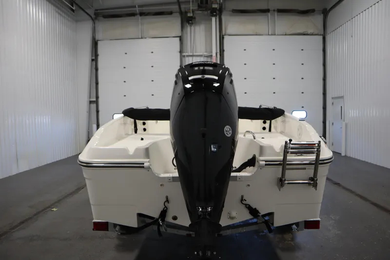 Slide: The Image of 2026 Bayliner Trophy T18 boat in a garage, rear view with outboard motor. - 5
