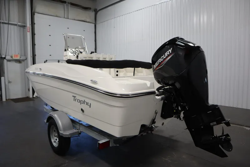 Slide: The Image of 2026 Bayliner Trophy T18 boat with Mercury outboard motor in a garage setting. - 6