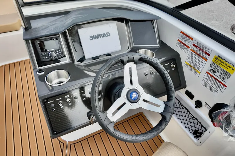 Slide: The Image of 2026 Bayliner VR6 boat dashboard with steering wheel, Simrad display, and control panel. - 11