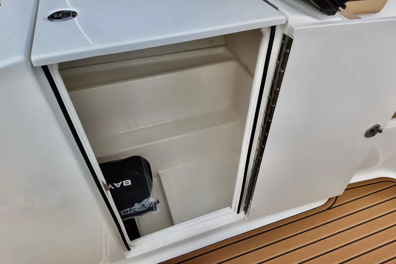 Slide: The Image of 2026 Bayliner VR6 boat storage compartment with open door on teak deck. - 12