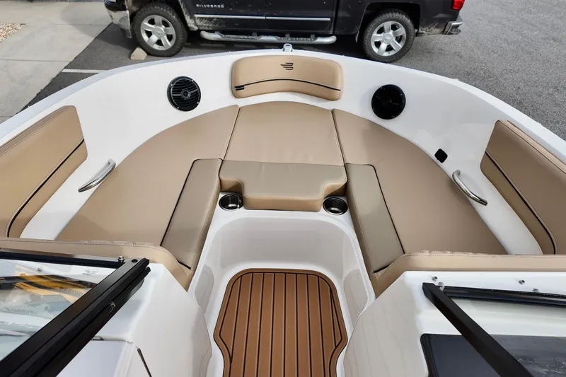 Slide: The Image of 2026 Bayliner VR6 boat interior with tan seating and wood-style flooring. - 6