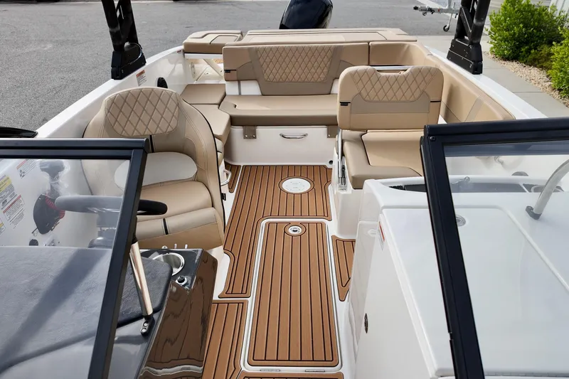 Slide: The Image of 2026 Bayliner VR6 boat interior with tan seating and wood-style flooring. - 7