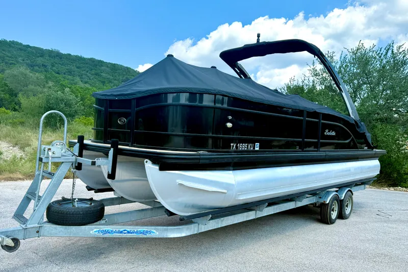 Slide: The Image of 2021 Barletta L25UC pontoon boat on trailer, covered, with scenic background. - 15