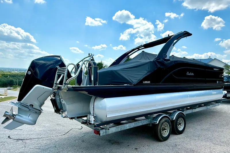 Slide: The Image of 2021 Barletta L25UC pontoon boat on trailer under blue sky. - 18