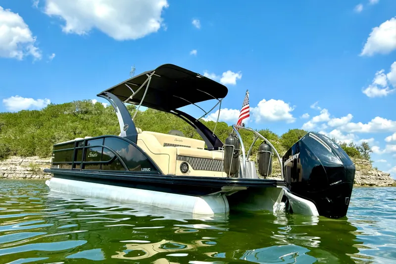 Slide: The Image of 2021 Barletta L25UC pontoon boat on a lake under a clear blue sky. - 3