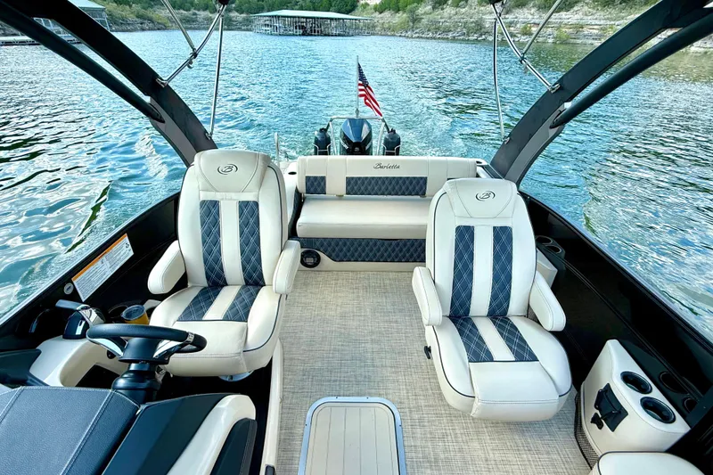 Slide: The Image of 2021 Barletta L25UC pontoon boat interior with luxury seating on a lake. - 32