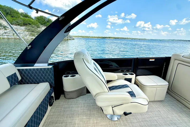 Slide: The Image of 2021 Barletta L25UC pontoon boat interior with luxurious seating and scenic lake view. - 33