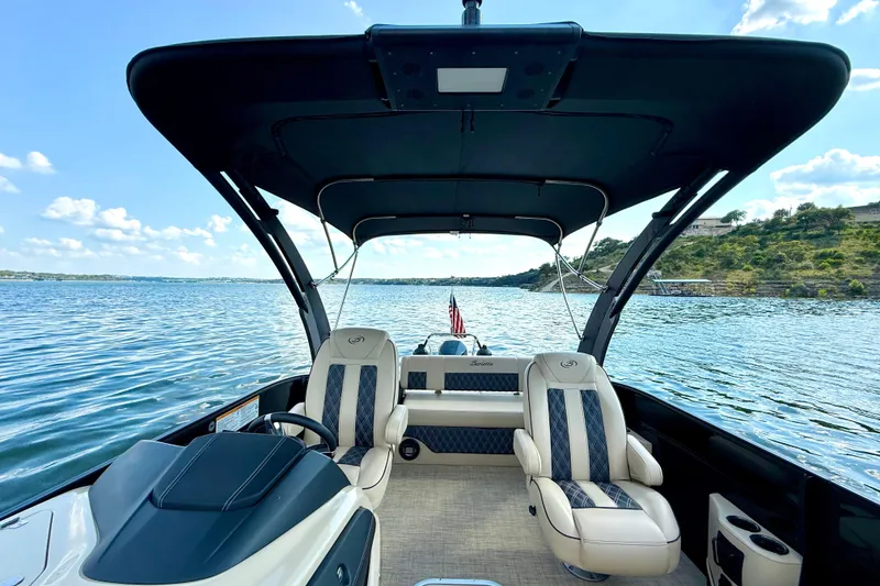 Slide: The Image of 2021 Barletta L25UC pontoon boat interior with lake view, featuring luxurious seating and canopy. - 35