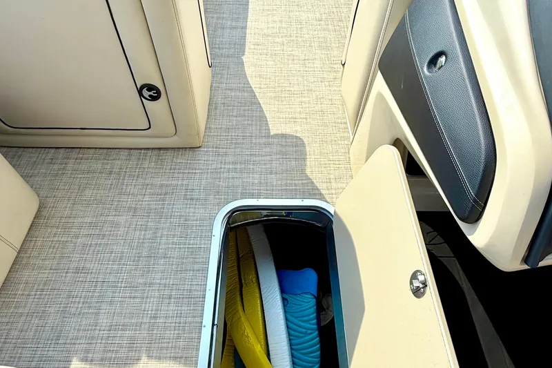 Slide: The Image of 2021 Barletta L25UC boat interior with open storage compartment and beige seating. - 36