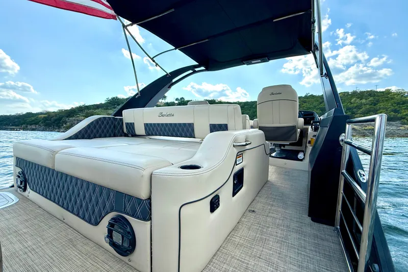 Slide: The Image of 2021 Barletta L25UC pontoon boat interior with luxurious seating and scenic lake view. - 41