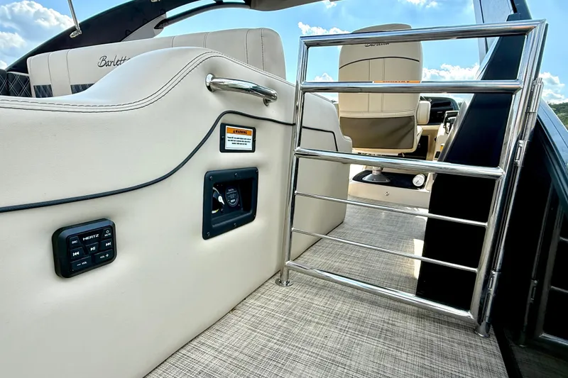 Slide: The Image of 2021 Barletta L25UC boat interior with seating, control panel, and safety gate. - 47