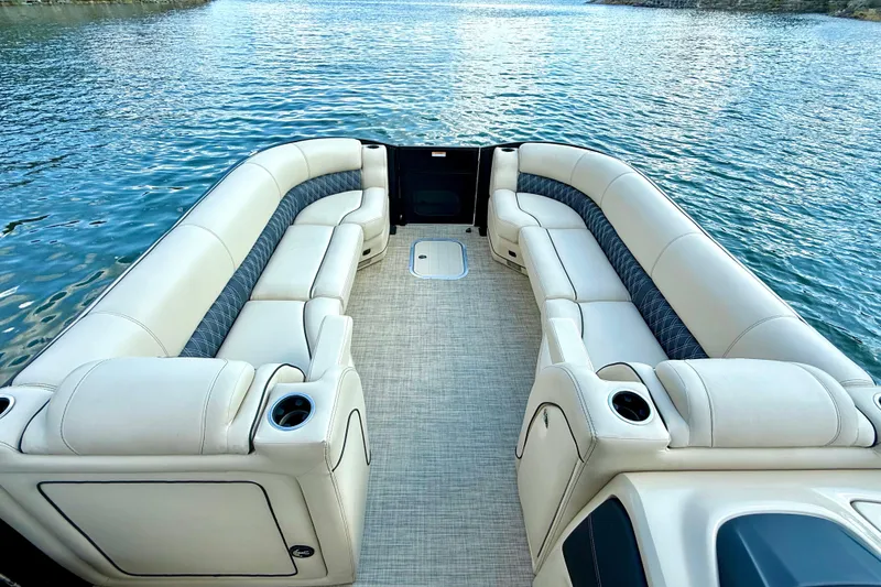 Slide: The Image of Luxurious 2021 Barletta L25UC pontoon boat interior with plush seating on a serene lake. - 48