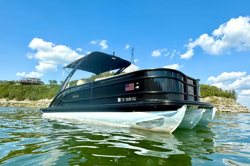 Slide: The Image of 2021 Barletta L25UC pontoon boat on a lake under a clear blue sky. - 6