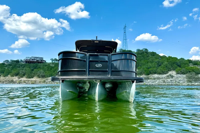 Slide: The Image of 2021 Barletta L25UC pontoon boat on a lake under a clear blue sky. - 8