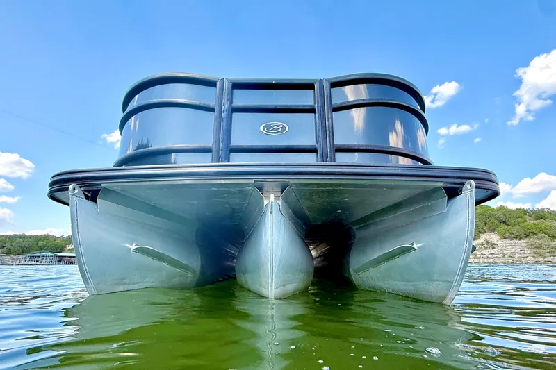 Slide: The Image of 2021 Barletta L25UC pontoon boat on water, under clear blue sky. - 9
