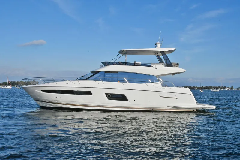 The Image of 2018 Prestige 560 Fly yacht on calm water under clear blue sky. - 0