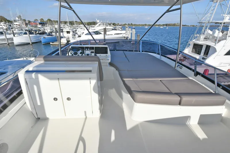 Slide: The Image of Flybridge of 2018 Prestige 560 Fly yacht with seating, overlooking marina. - 12