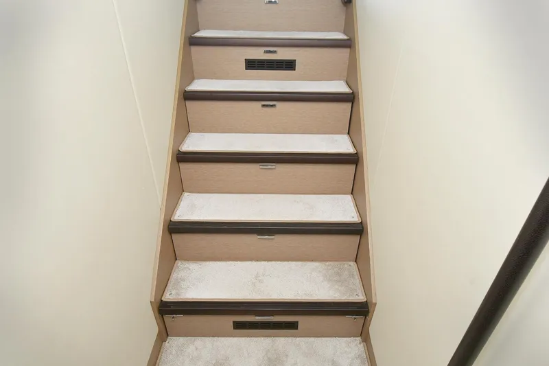 Slide: The Image of Staircase inside 2018 Prestige 560 Fly yacht, featuring carpeted steps and wooden accents. - 33