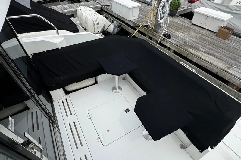 Slide: The Image of 2019 Cruisers Yachts 42 Cantius deck with black seating and tables at dock. - 14
