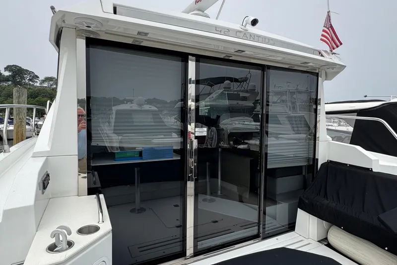 Slide: The Image of 2019 Cruisers Yachts 42 Cantius with sleek glass doors and American flag. - 6