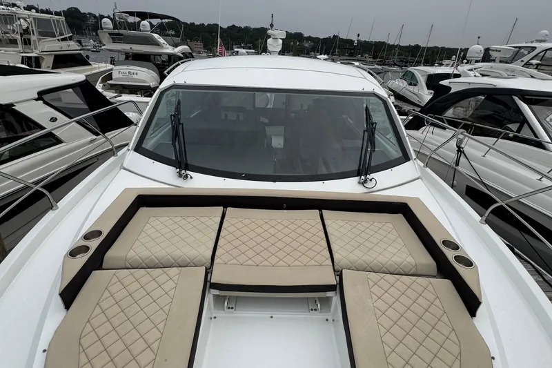 Slide: The Image of 2019 Cruisers Yachts 42 Cantius with beige seating, docked among other boats. - 8